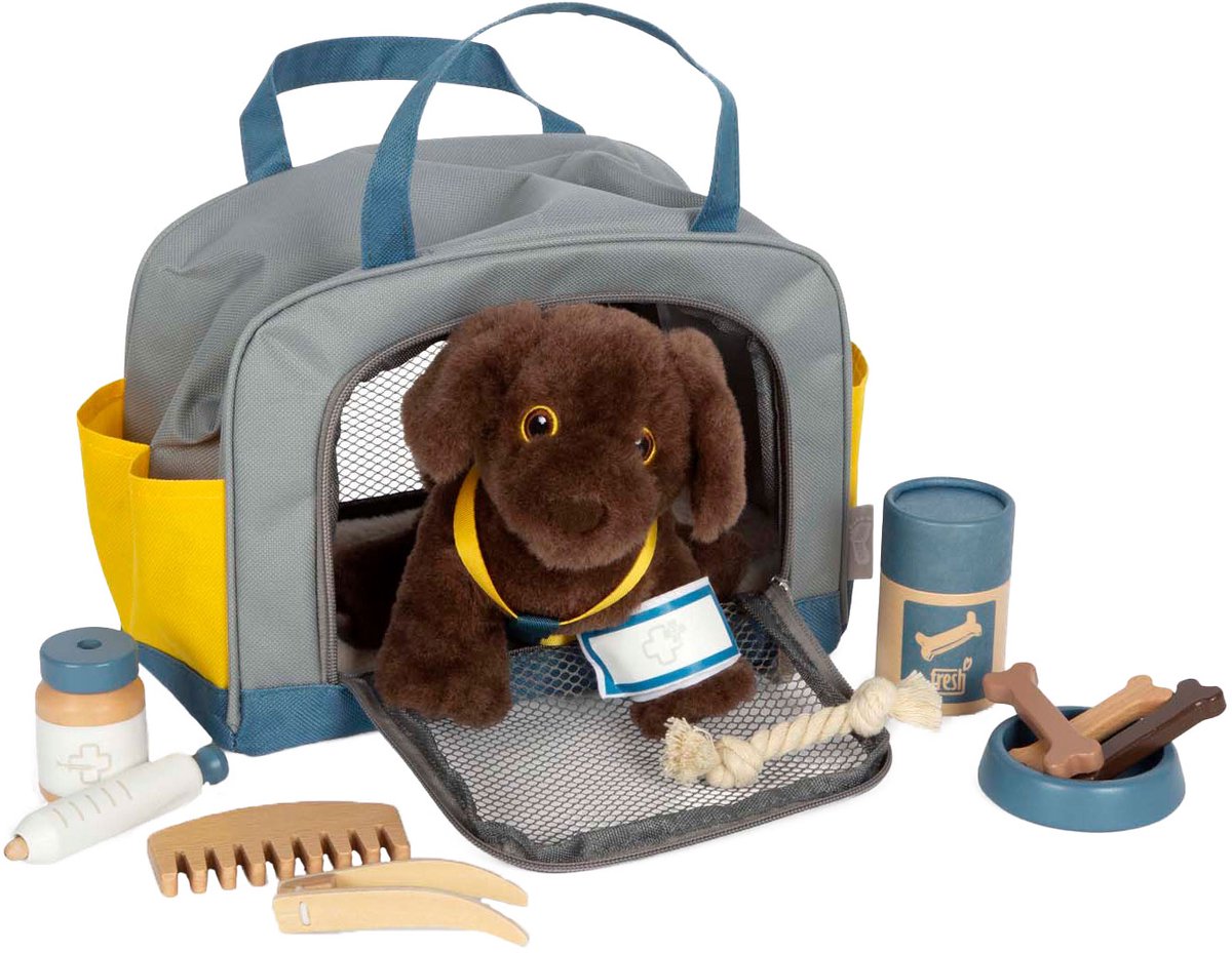 Petit chien de câlins avec un sac de transport et un ensemble de soins