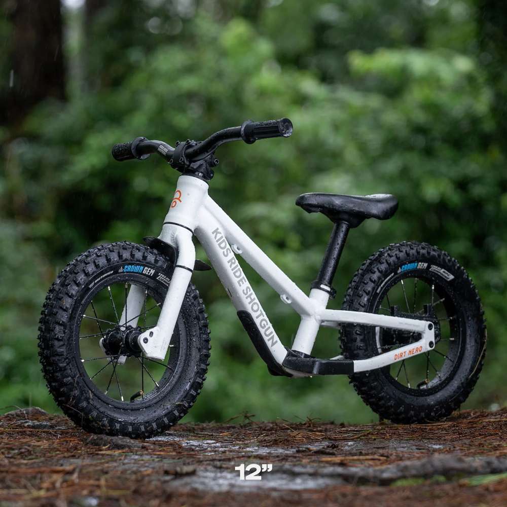 Les enfants montent sur un vélo d'équilibre Dirt Hero avec fusil de chasse 12